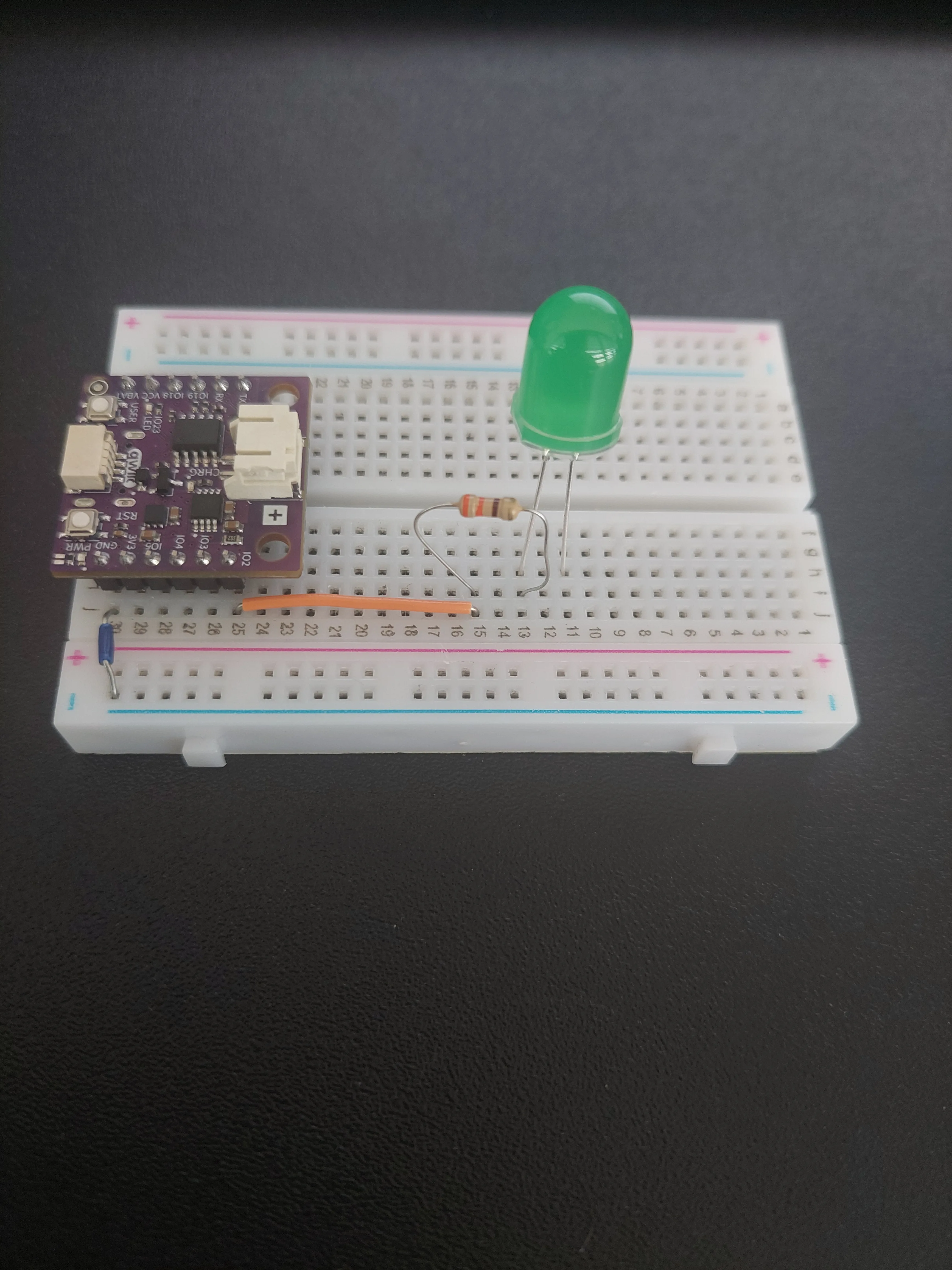 LED added, with its long leg in row 13 alongside the resistor and its short leg in row 11